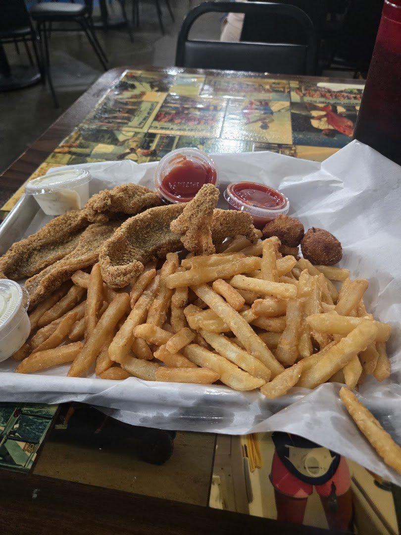 Golden fried oysters beside lemon wedges and dipping sauce.
